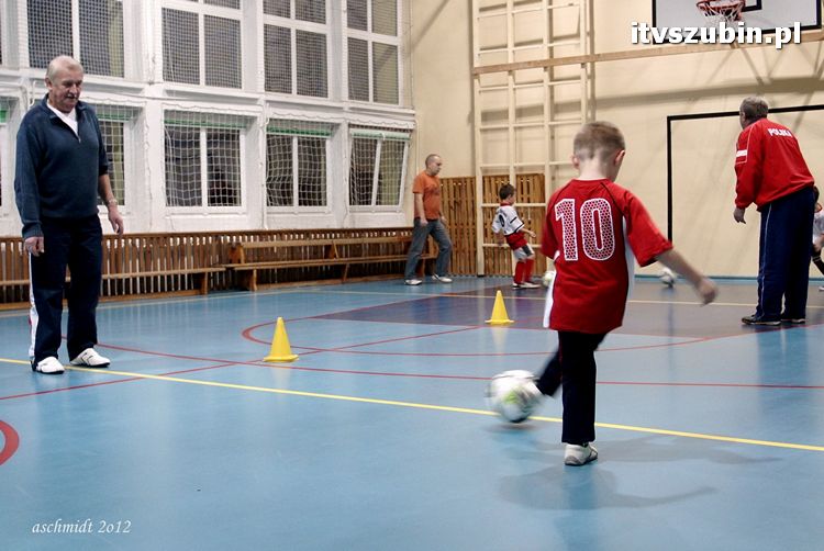 Młodzi piłkarze trenują i zdobywają umiejętności pod czujnym okiem trenera