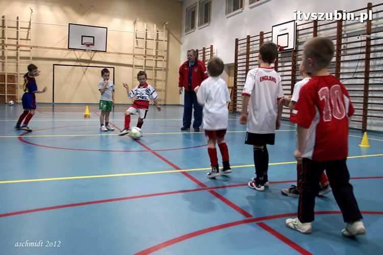 Młodzi piłkarze trenują i zdobywają umiejętności pod czujnym okiem trenera